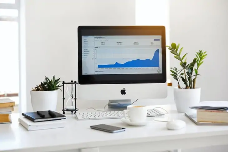 Exibindo as estatísticas do Google Analytics em uma tela de desktop em uma mesa branca
