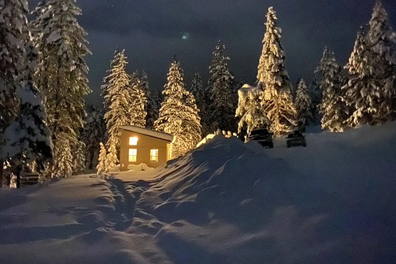 pequeña casa rodeada de nieve