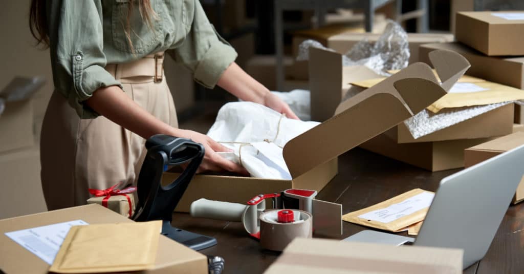 Eine Frau verpackt Produkte aus ihrem Online-Shop für den Versand