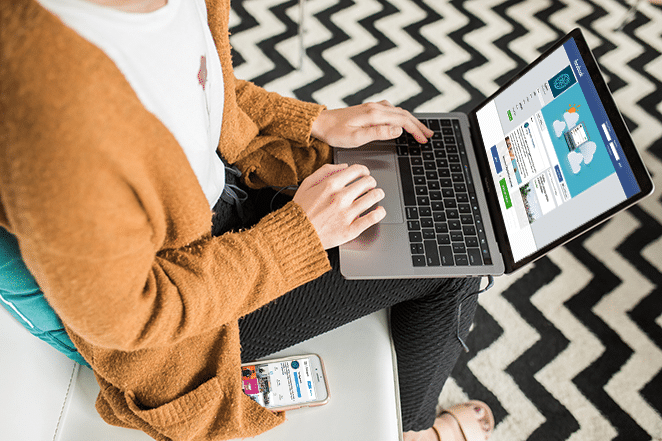 frau auf couch mit facebook auf laptop und instagram am telefon checkt soziale medien