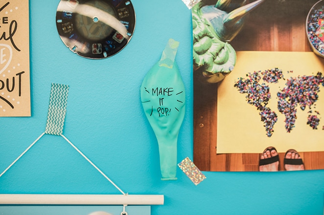Ballon mit Make It Pop darauf geschrieben und an eine Inspirationswand geklebt, um Social-Media-Inhalte hervorzuheben