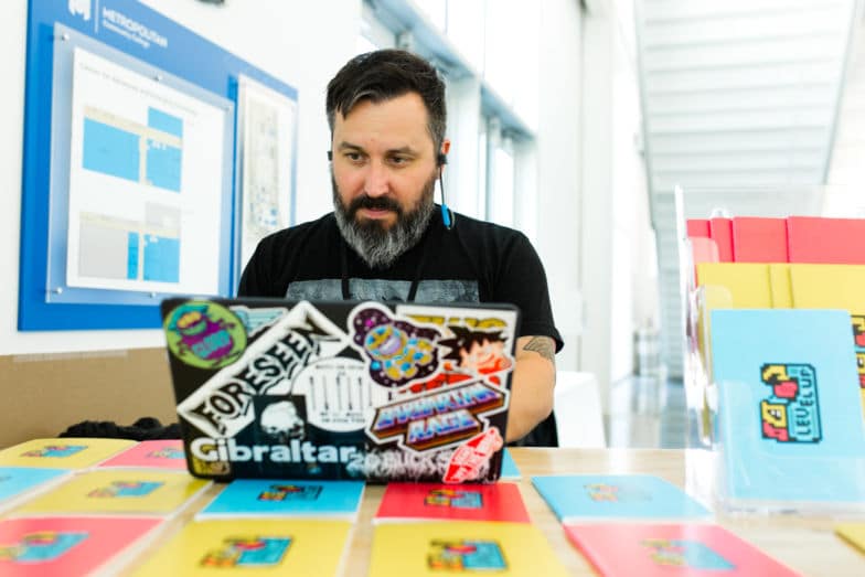 Homem com barba trabalha no computador à mesa.