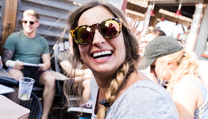diseño del bloque del diseñador del volante mujer con gafas de sol reflectantes riéndose entre amigos al aire libre