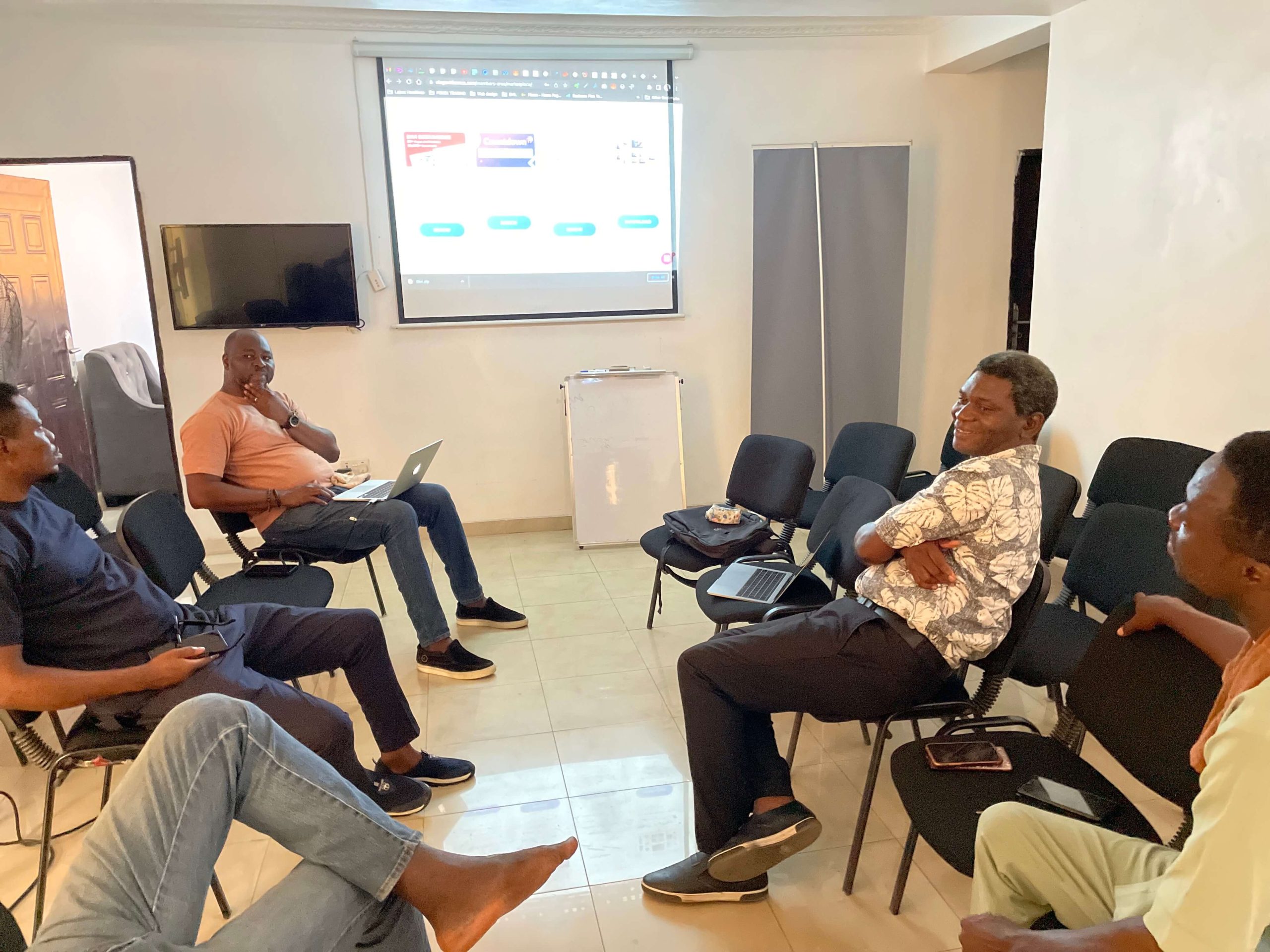 grupo de nigerianos sentados en círculo discutiendo Divi