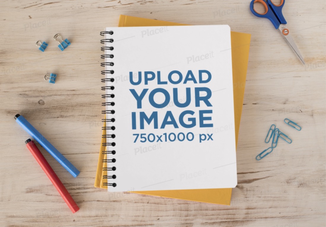 mockup di un quaderno a spirale su una superficie di legno con forniture di cancelleria