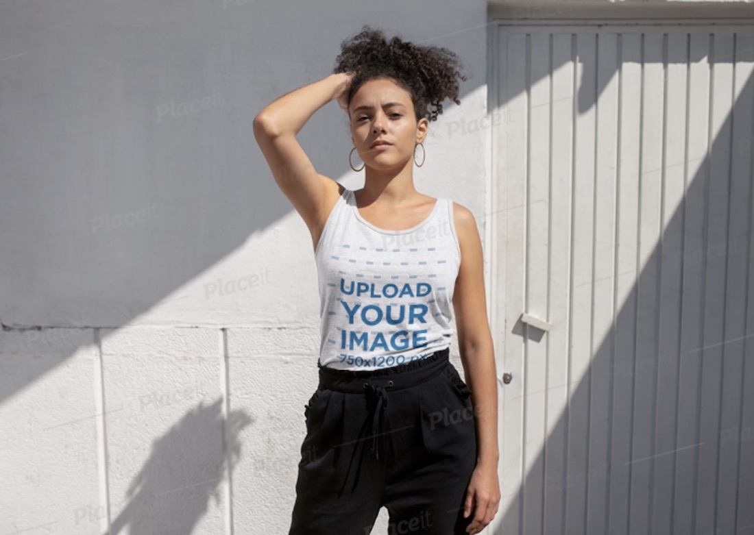 maqueta de camiseta sin mangas de una mujer posando delante de una pared blanca y una puerta