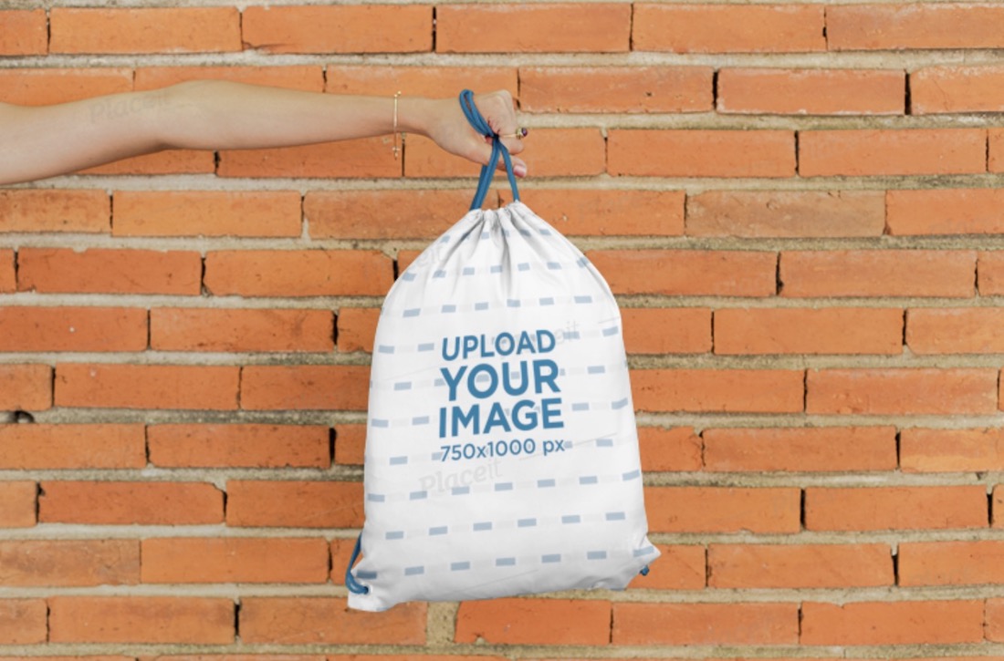 mockup tangan memegang tas serut