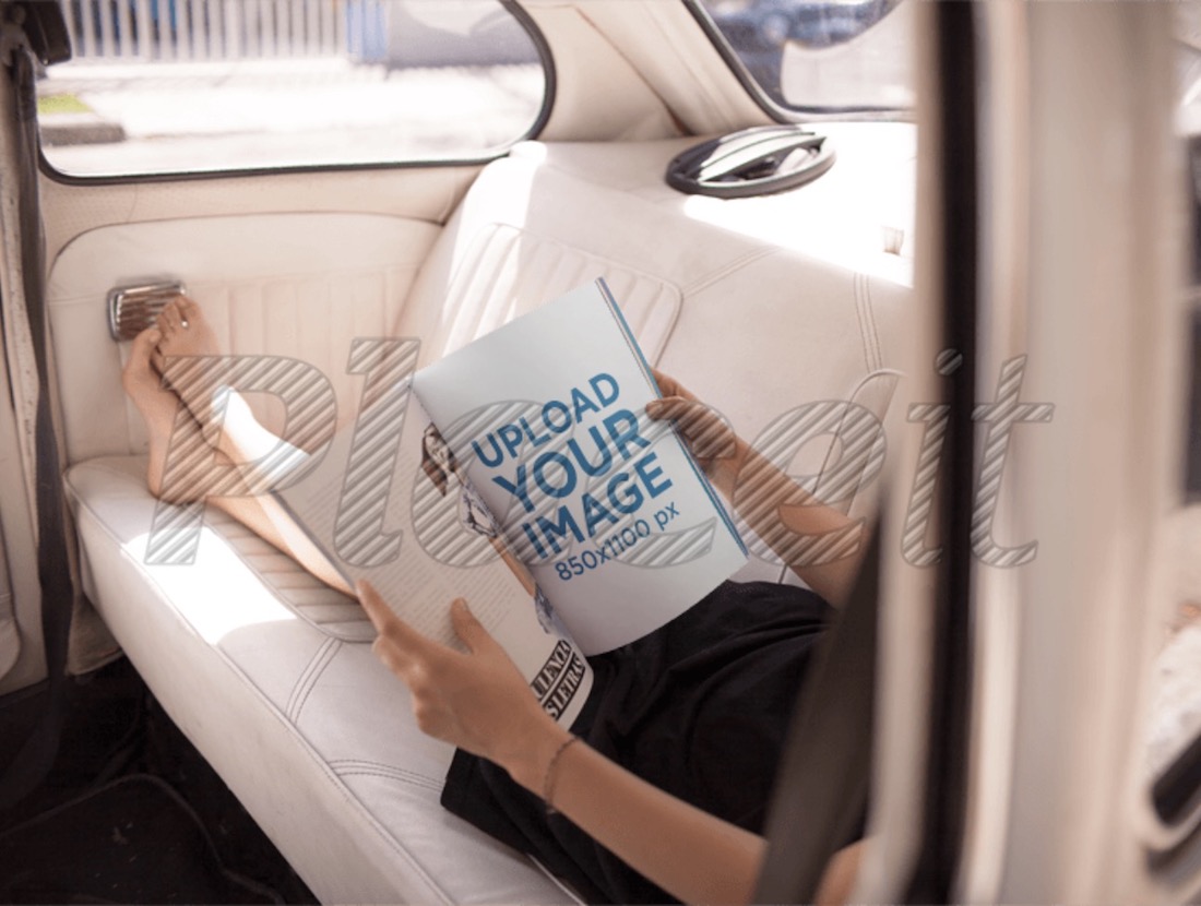 車のモックアップの後ろで雑誌を読んでいる女性