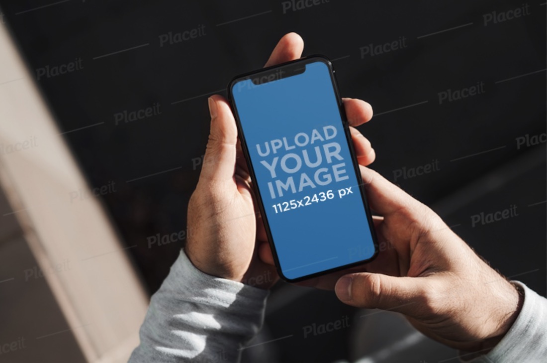 mockup di un uomo che tiene un iphone 11 pro con entrambe le mani