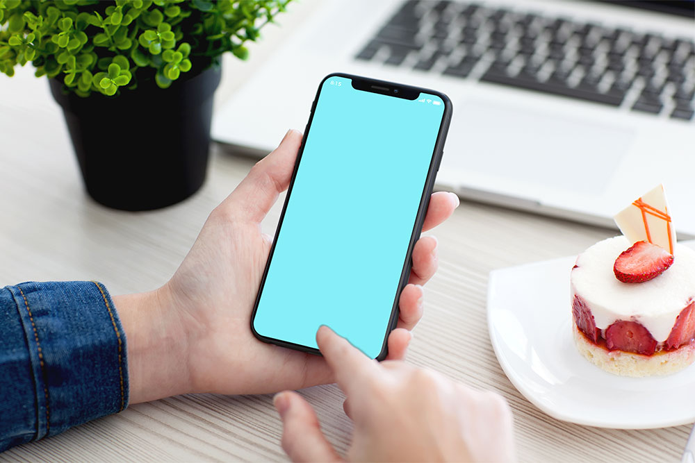 mano maschile che tiene il modello di iphone x psd