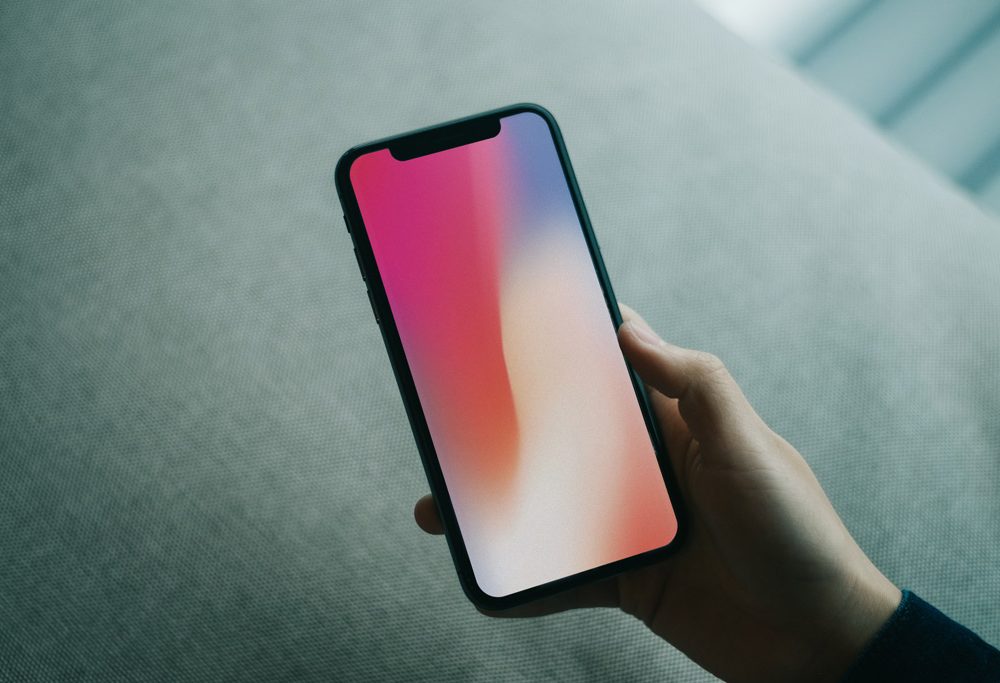 mano che tiene il modello di iphone x psd