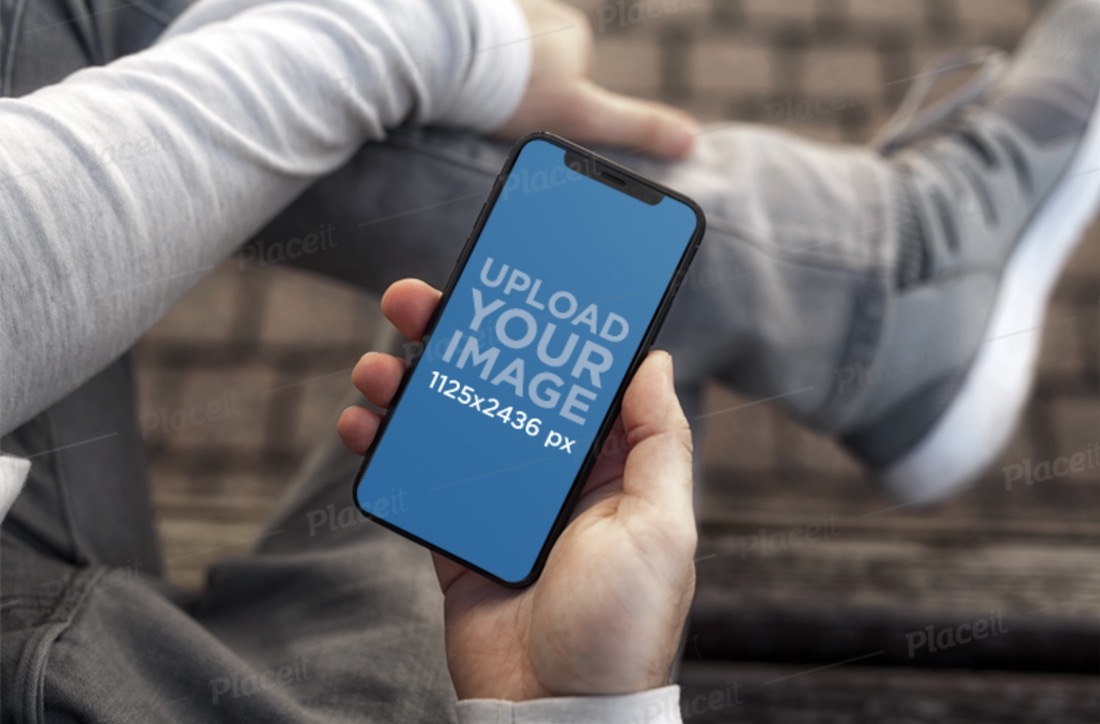 mockup di un giovane con in mano un iphone 11 pro